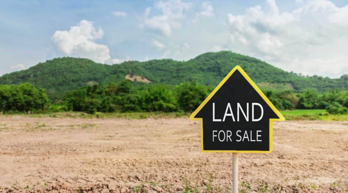 A land for sale sign in the middle of a field
