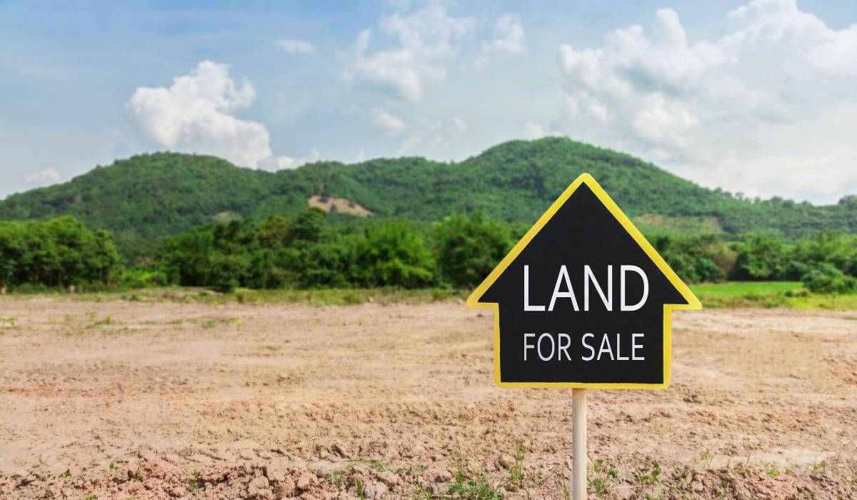 A land for sale sign in the middle of a field
