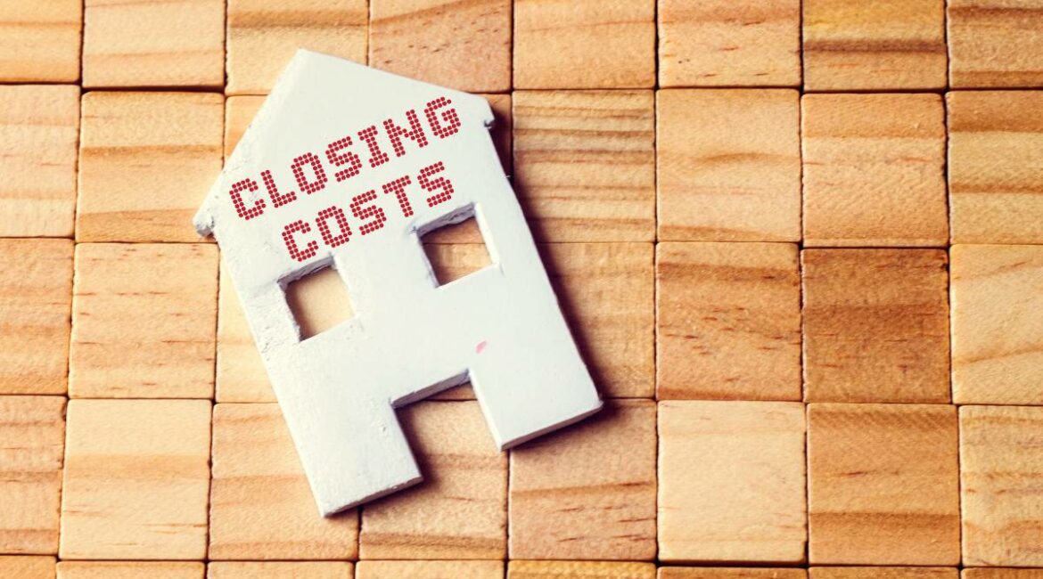 Closing costs written on a cut out of a house with wooden blocks on the background to show a pre-construction condo.