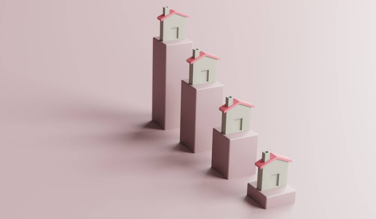 A group of small houses in descending order on a pink background
